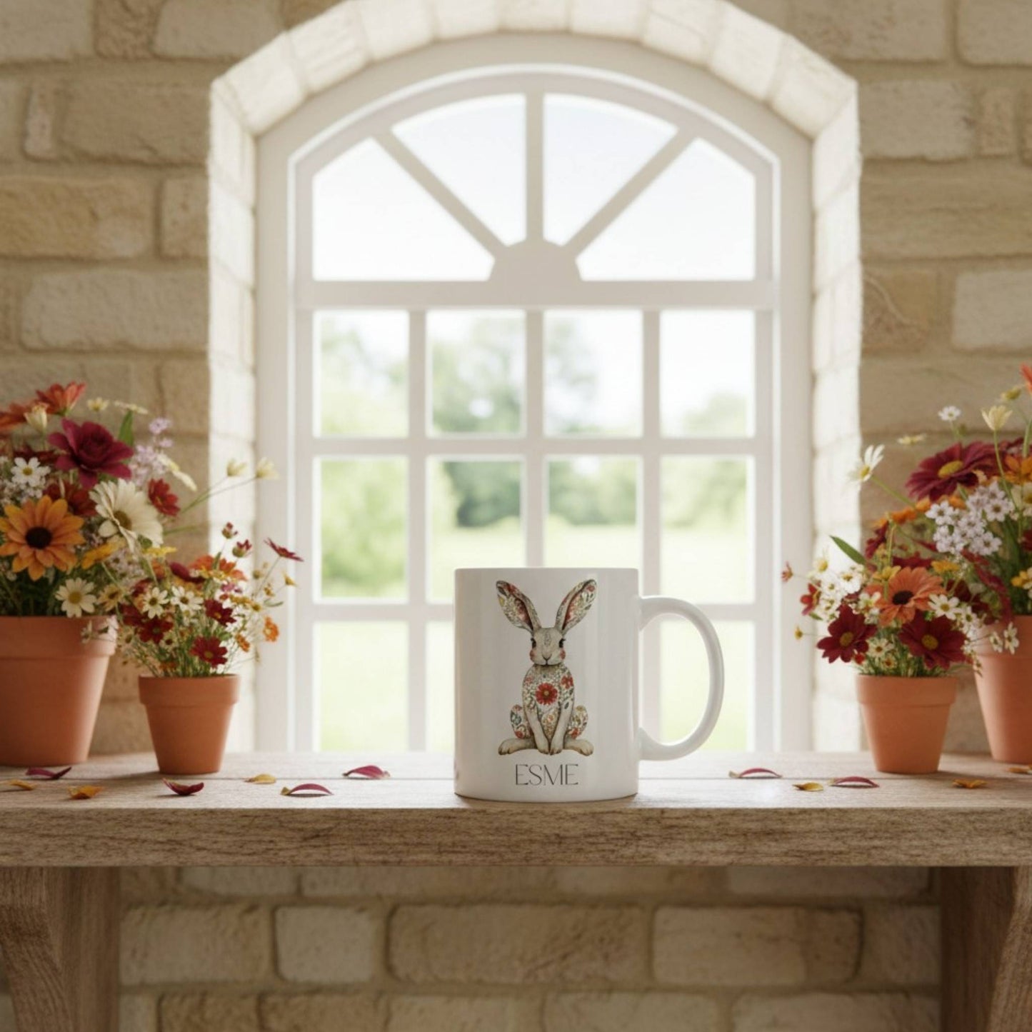 White mug with a hare design on a windowsill with flowers