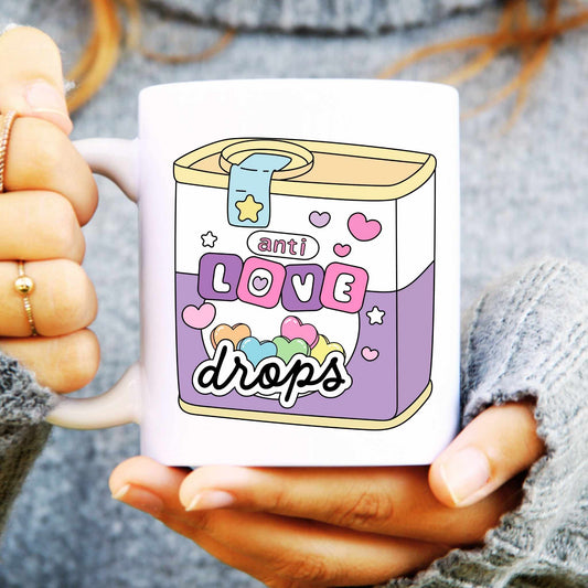 White ceramic mug with a illustration of a tin, text reads "Anti Love Drops"