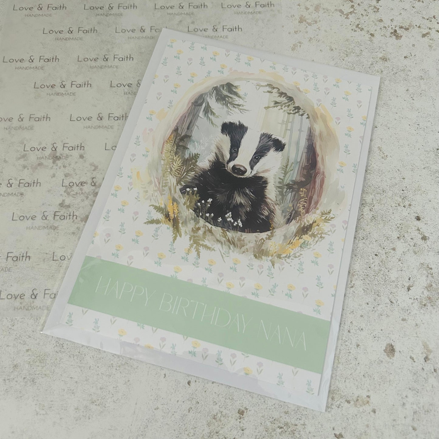 Greeting card with a badger illustration and 'Happy Birthday Nana' text on a textured surface.