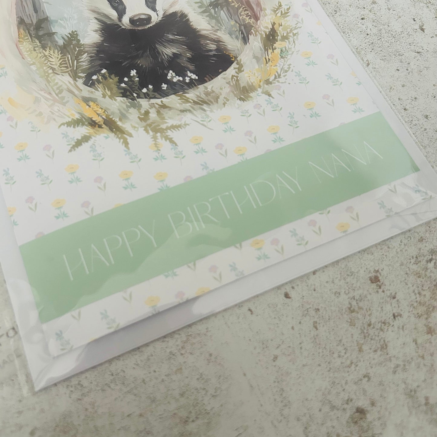Greeting card with a badger illustration and 'Happy Birthday' text on a textured surface.