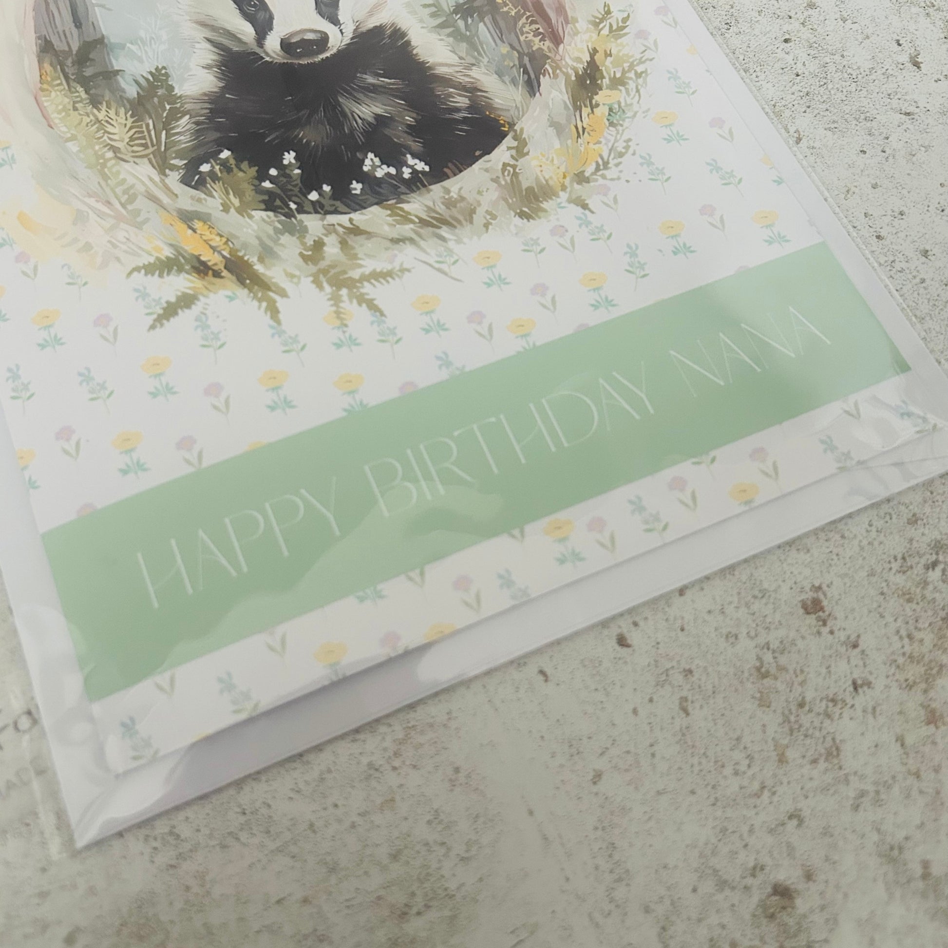 Greeting card with a badger illustration and 'Happy Birthday' text on a textured surface.