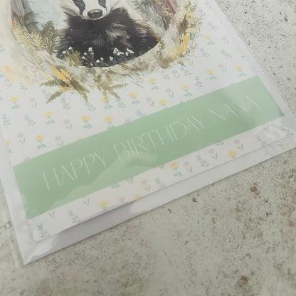 Greeting card with a badger illustration and 'Happy Birthday' text on a textured surface.