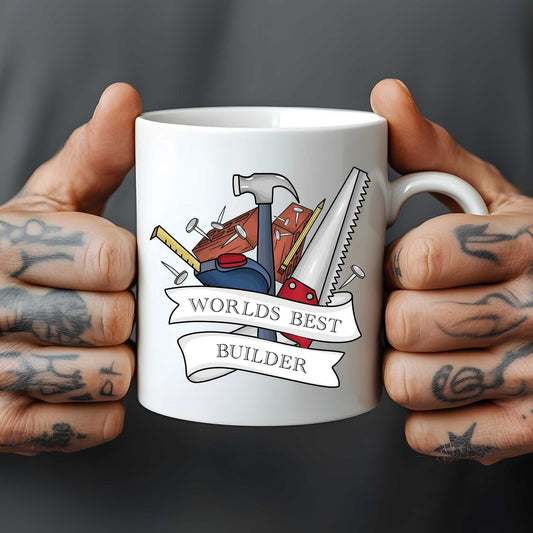 White mug held by hands with tattoos, featuring construction tools and 'World's Best Builder' text.