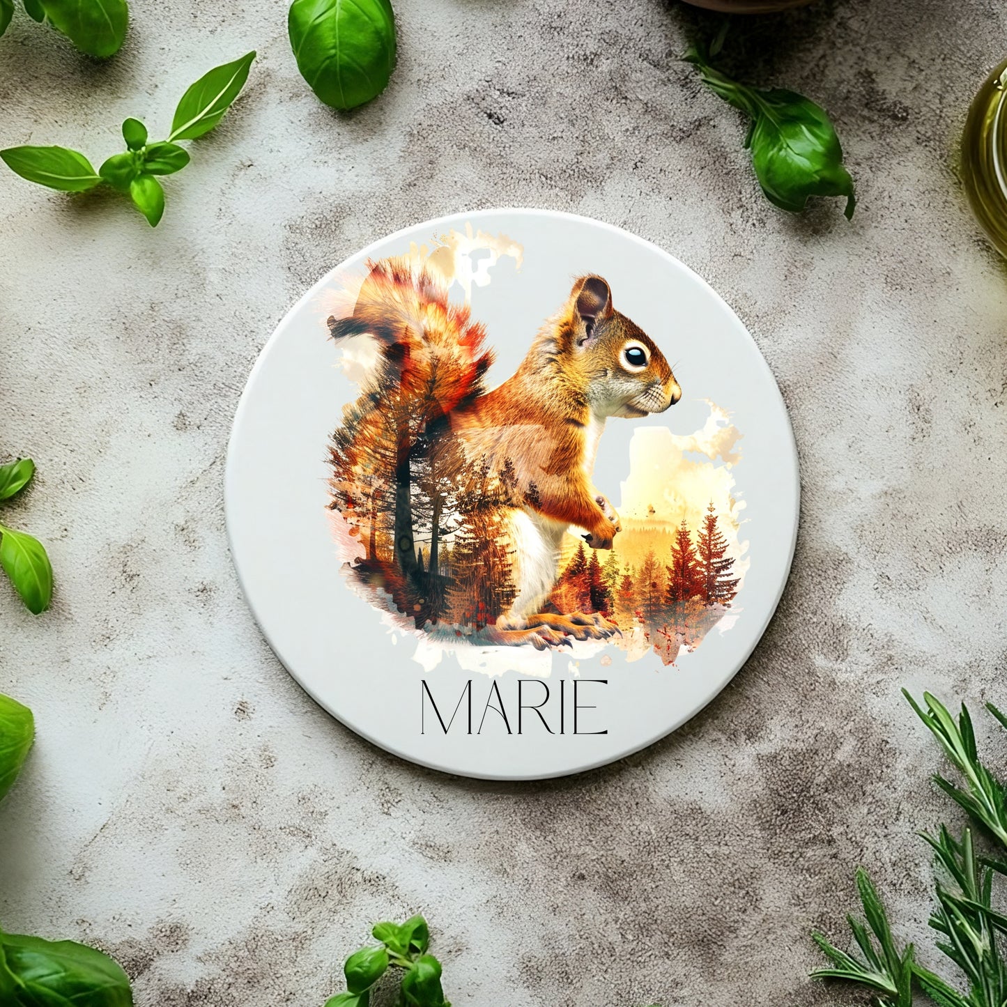 Round coaster with a squirrel design and the name 'MARIE' on a textured surface with basil leaves.