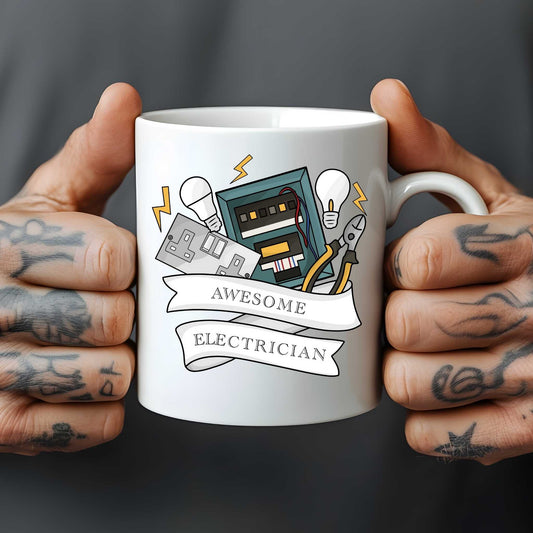 White mug held by tattooed hands with an illustration of tools and text 'Awesome Electrician' on a dark background.