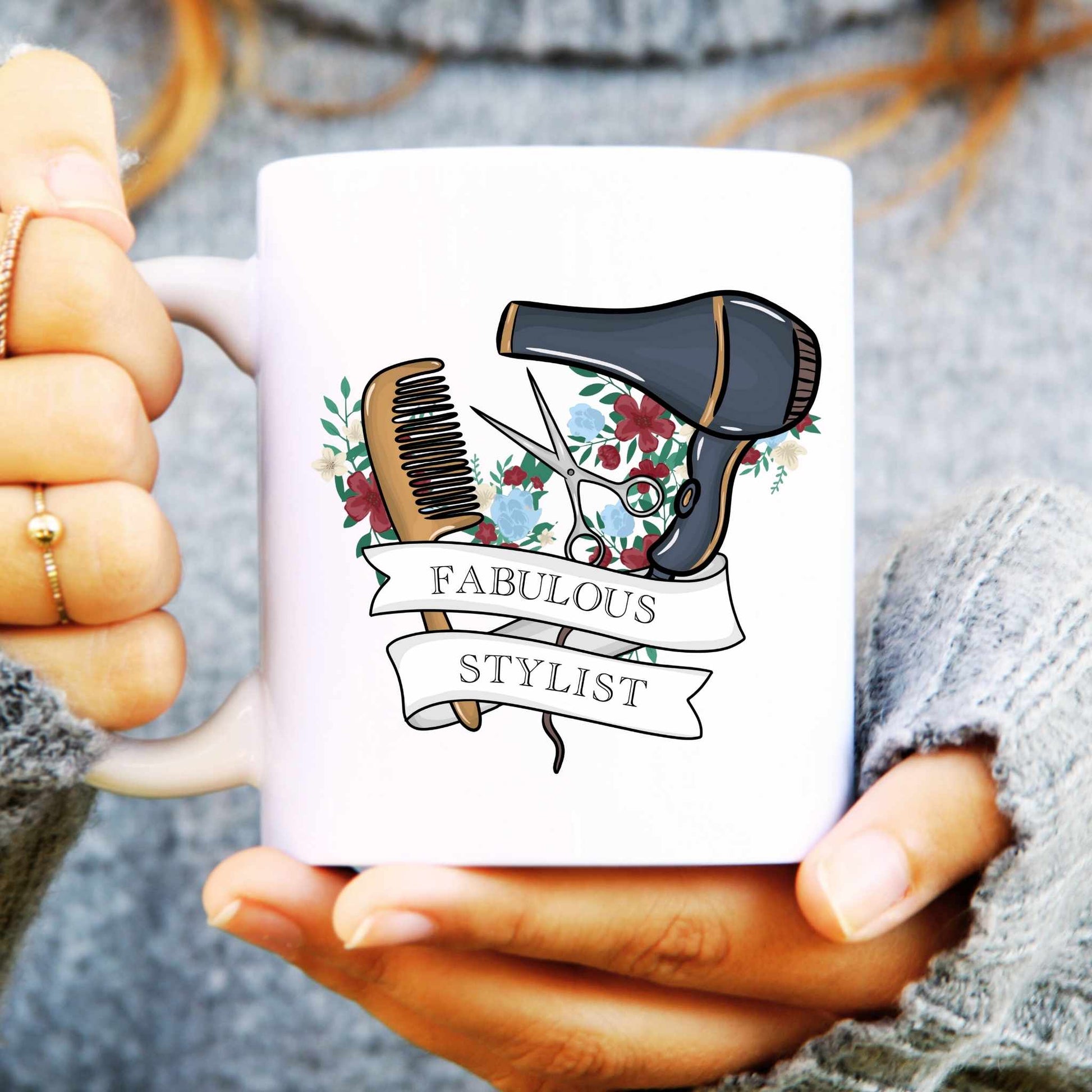 White mug with a comb and hair dryer design and 'Fabulous Stylist' text, held by hands.