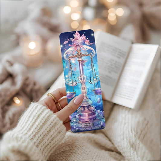 Person holding a Libra bookmark with a fantasy design against a cosy background