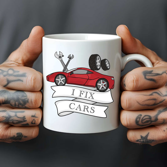 White mug with 'I Fix Cars' design held by hands with tattoos on a dark background