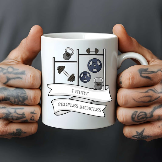 White mug held by tattooed hands with gym-themed design and text.