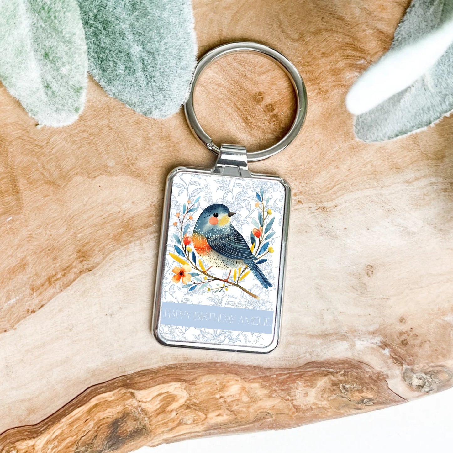 Keychain with a bird design on a wooden surface