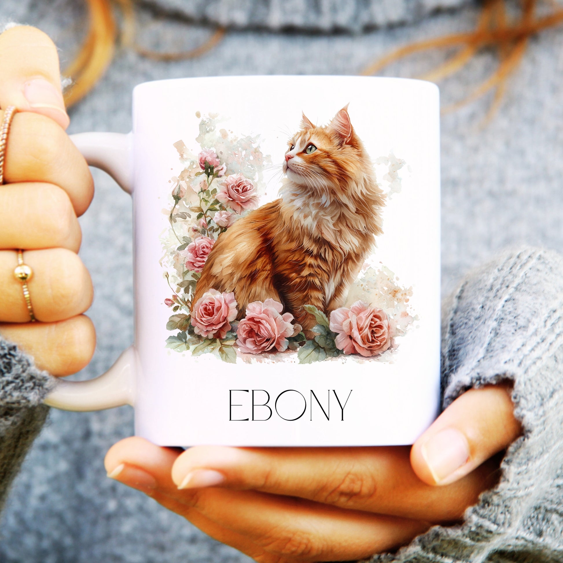 Person holding a mug with a ginger cat and floral design, personalised 'EBONY'.