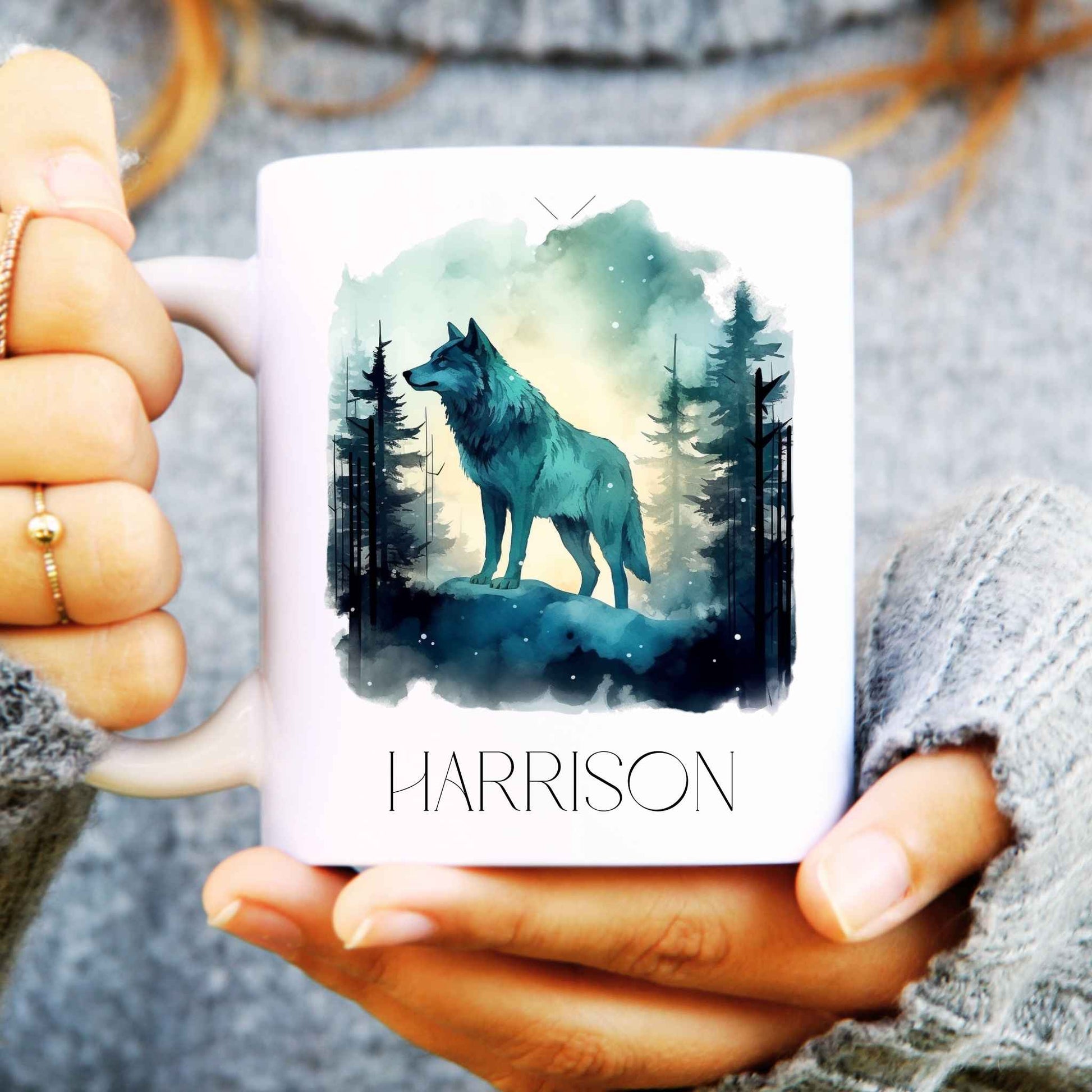 Ceramic coffee mug held in hands with a gorgeous wolf design in a forest and personalised with a name.