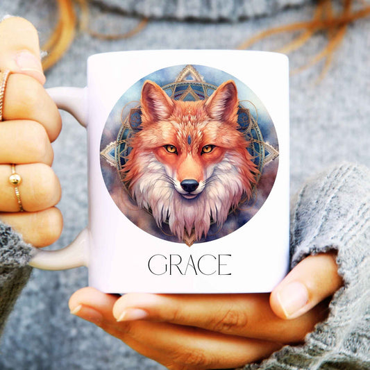 Ceramic mug being held with mandala fox design to the front and personalised with a name.