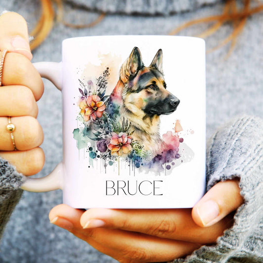Person holding a mug with a colourful German Shepherd dog illustration and 'BRUCE' text.