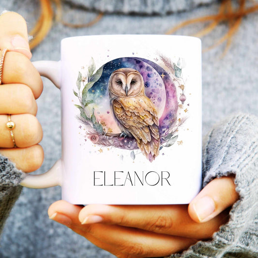Person holding a mug with an owl design and the name 'Eleanor' on it.