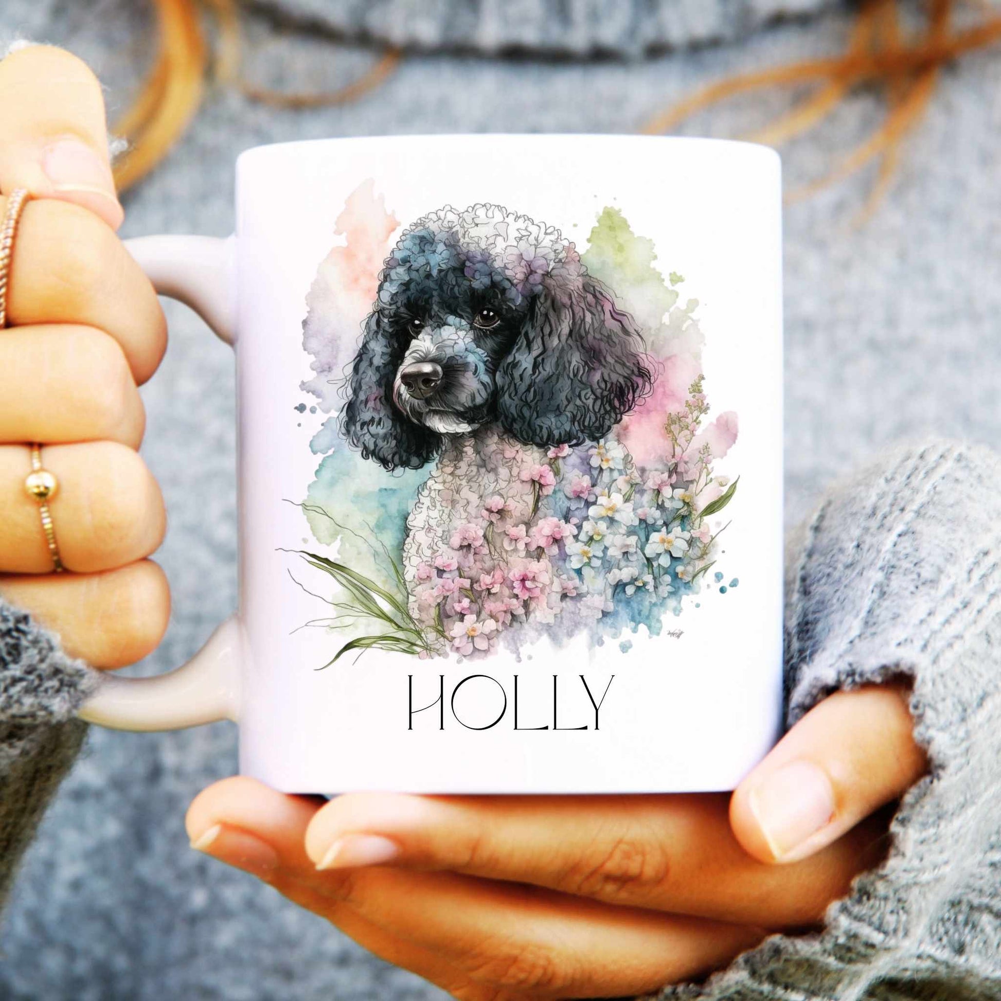 Person holding a mug with a poodle dog illustration and the name 'HOLLY'.
