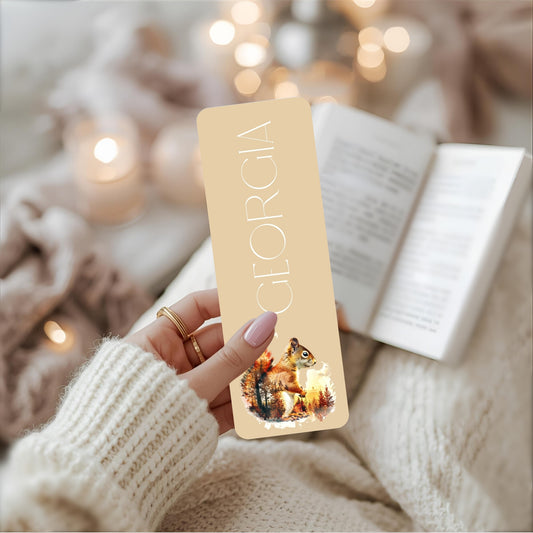 Hand holding a 'Georgia' branded bookmark with a cute squirrel.