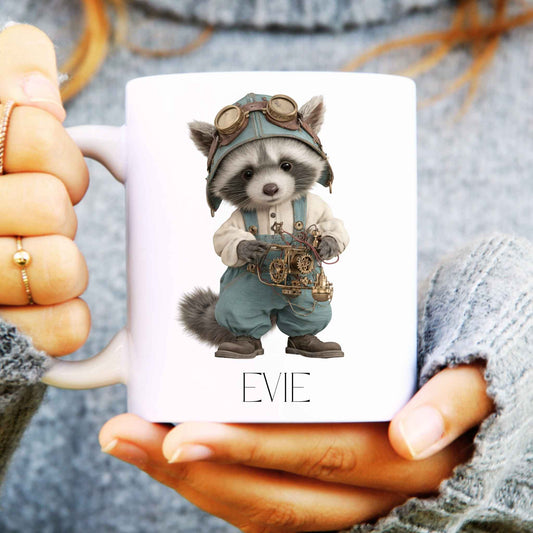 White ceramic coffee mug being held in hands with a raccoon design in steampunk form and personalised with a name.