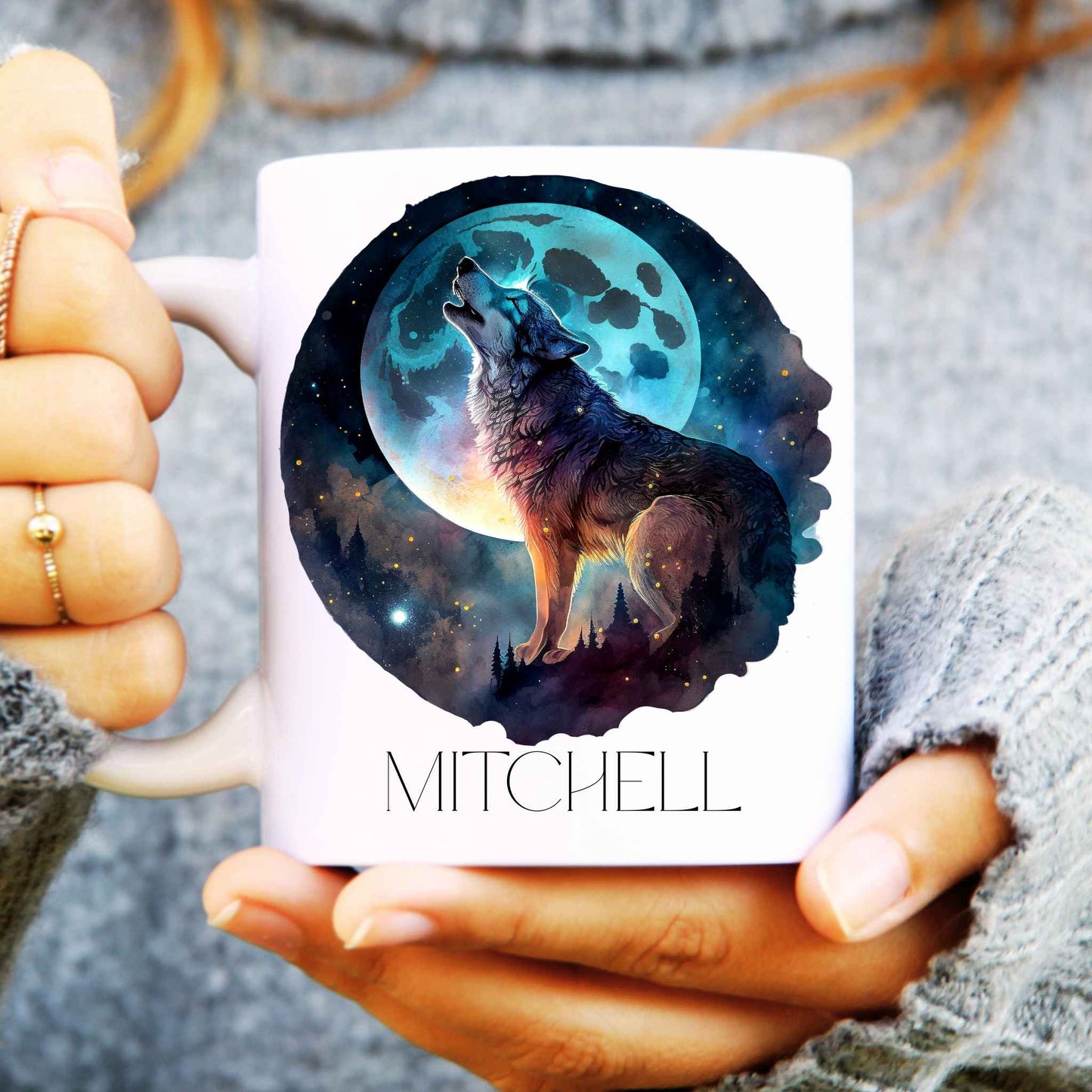 Ceramic mug held in hands with a howling wolf and the moon behind, personalised with a name.