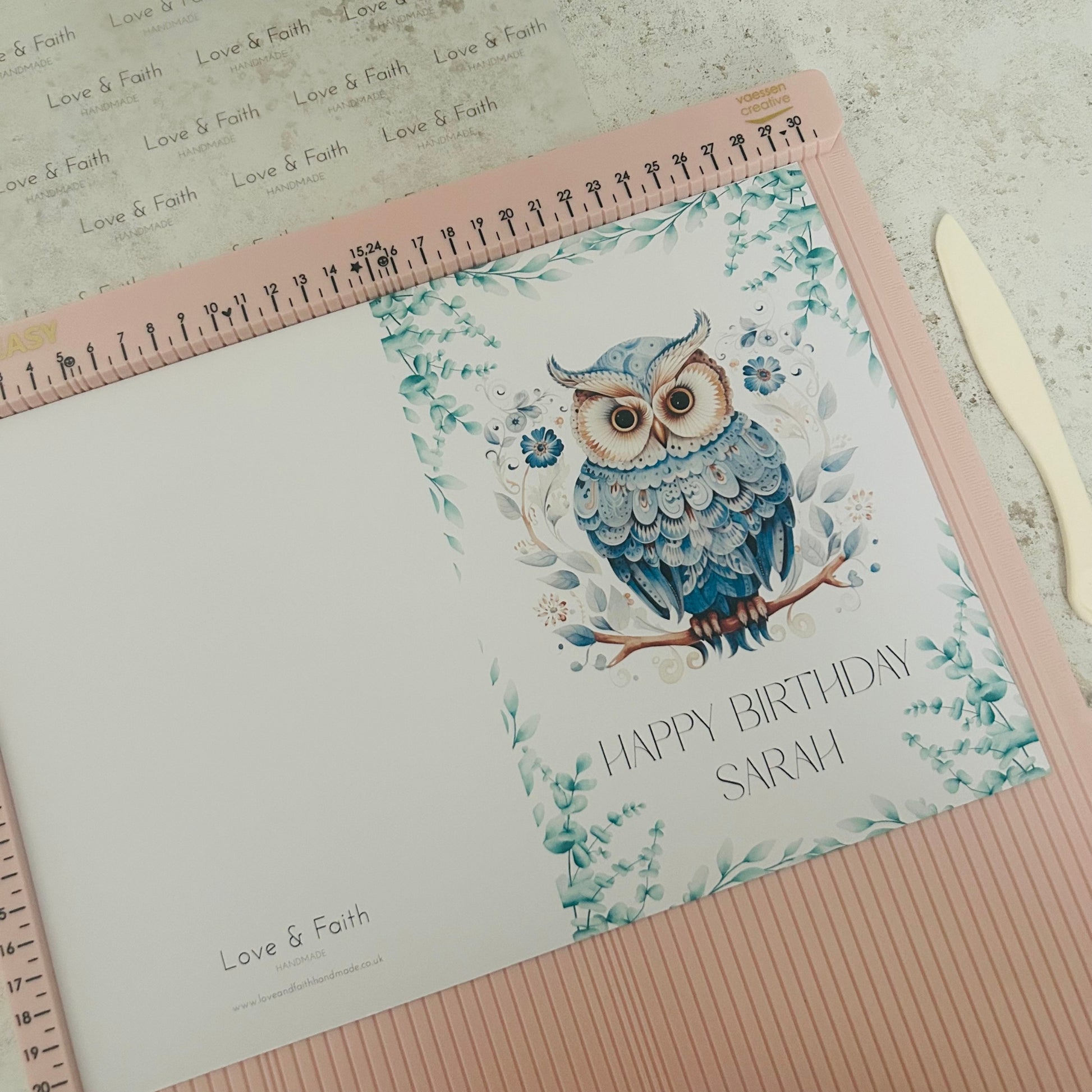 Greetings card with owl design and 'Happy Birthday Sarah' text on a textured surface.
