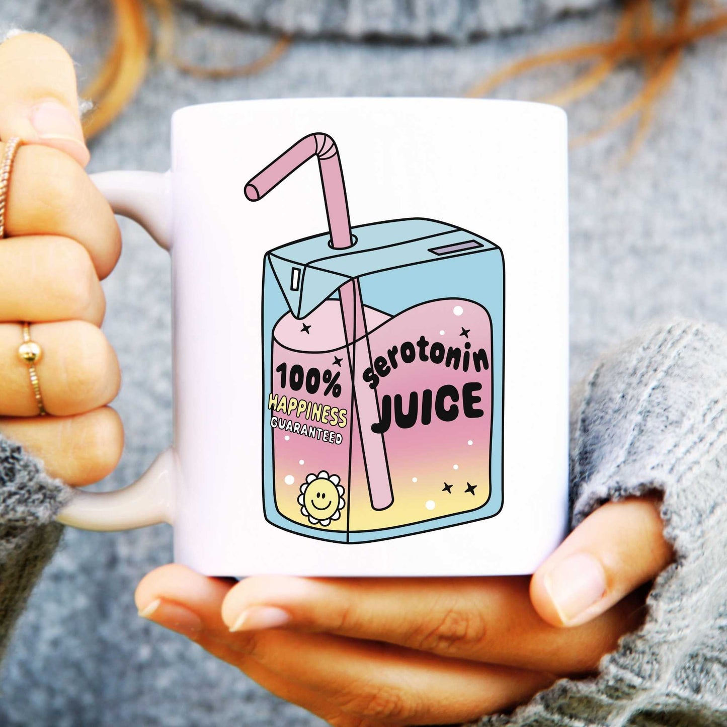 Mug held in hands with drinks carton illustration, text reads "Serotonin Juice"