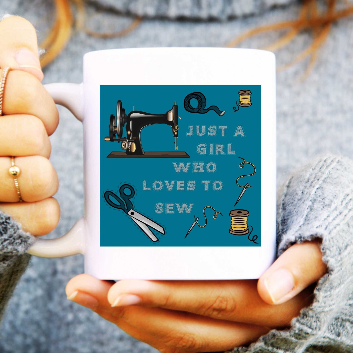 Person holding a mug with a sewing-themed design and text.