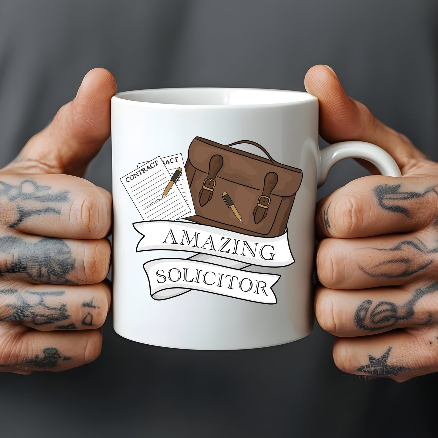 White mug held by tattooed hands with an illustration of a briefcase, contract, and text 'Amazing Solicitor' on a dark background.