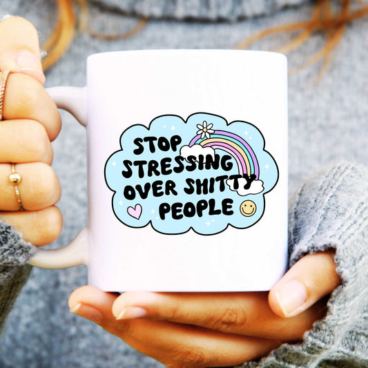 Person holding a mug with a motivational quote and colorful design.