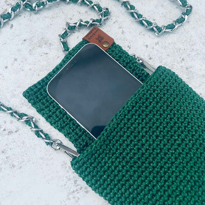 Green knitted phone pouch with chain strap on a light grey background