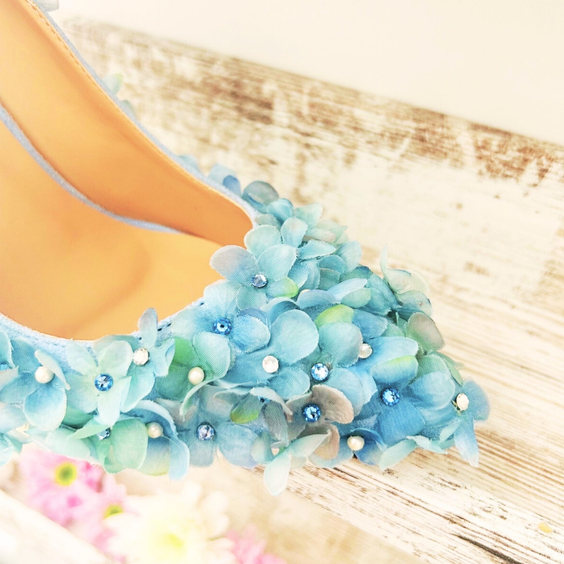 Blue floral shoes with rhinestones on a wooden floor
